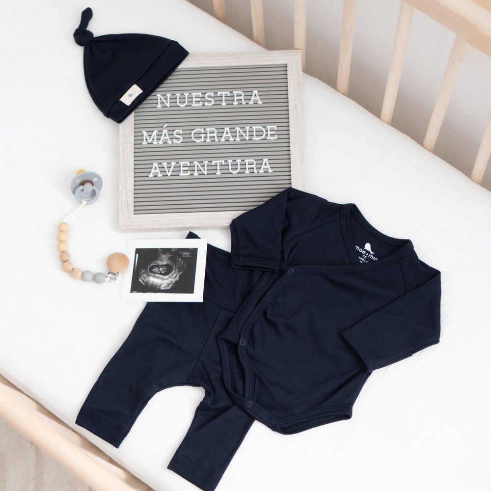 Set azul marino de Mae & Mini en la cuna con letrero Nuestra más grande aventura