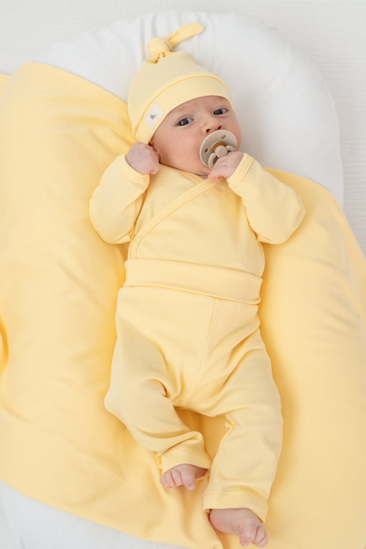 Bebé recién nacido con conjunto amarillo de Mae & Mini, un regalo que sí se usa