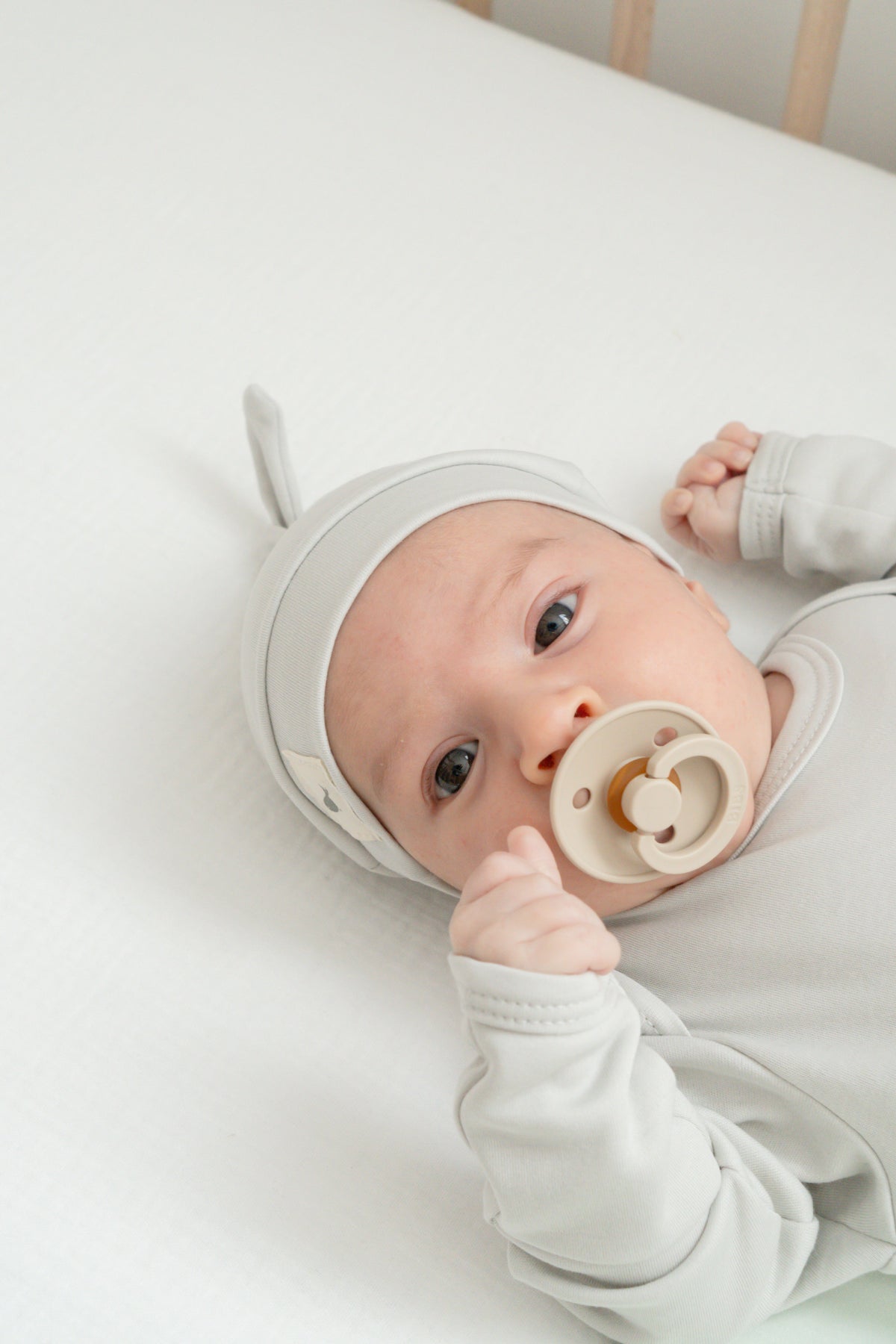 Bebé recién nacido con conjunto y gorrito de nudo en verde salvia